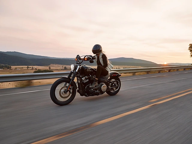 A rider on a cruiser motorcycle on an open highway