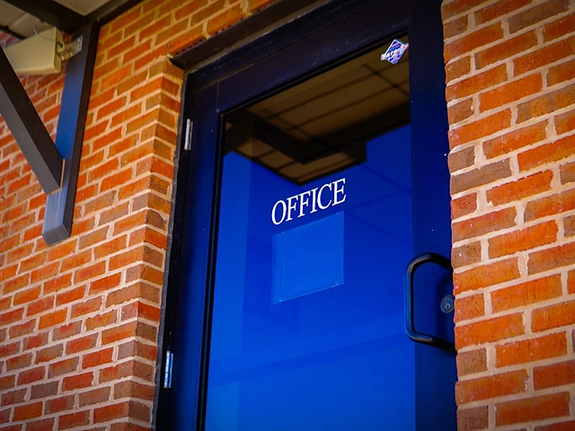 A blue office door set in a brick commercial building