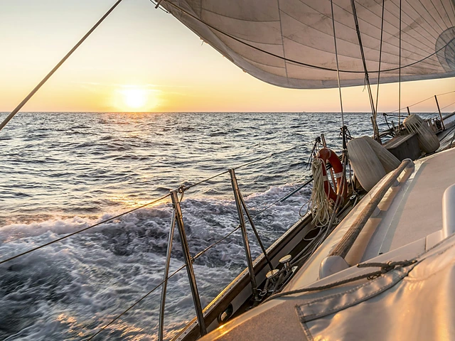 Sailing a yacht through open water at golden hour